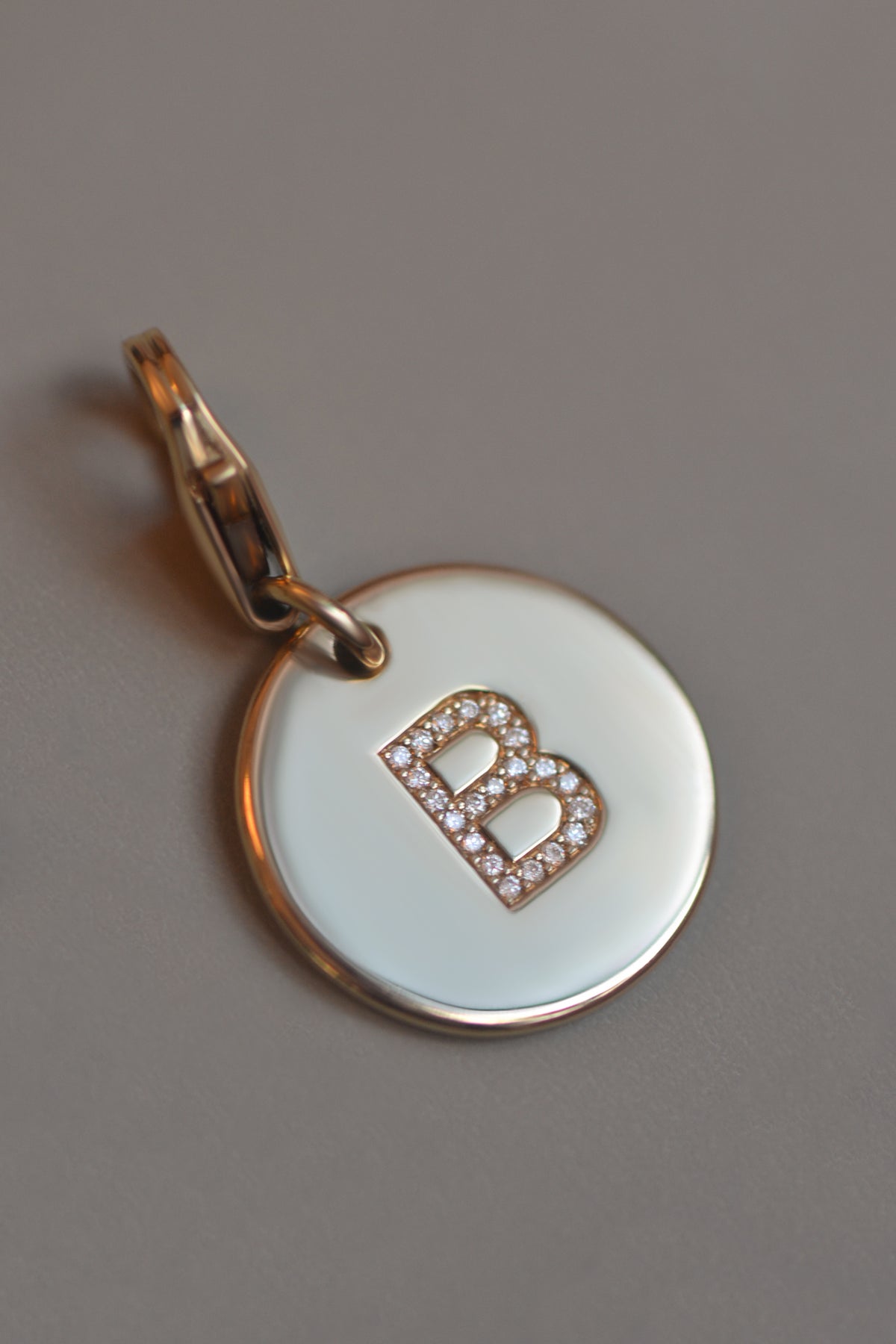 EMINENCE by PAWVÉ. A solid 9ct yellow gold round pendant with natural diamond flush set initial. FIne jewellery for pets.