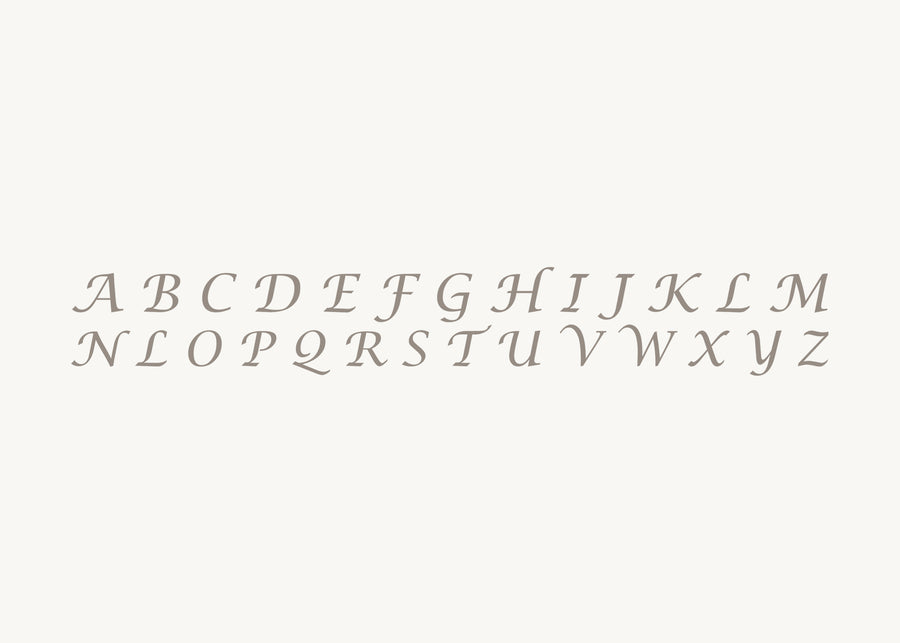 PAWVÉ's pet pendants are engraved with Lucida Calligraphy font style. Image depicts available A - Z initial style. Clients provide their pets name and PAWVÉ custom-engraves their chosen initial on select solid sterling silver or yellow gold pendants.