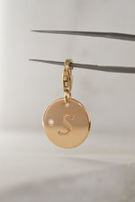 Solid 9ct yellow gold pendant, with natural round brilliant cut white diamond, engraved 'S' initial. Photographed on a neutral background. SOLÈNE by PAWVÉ.