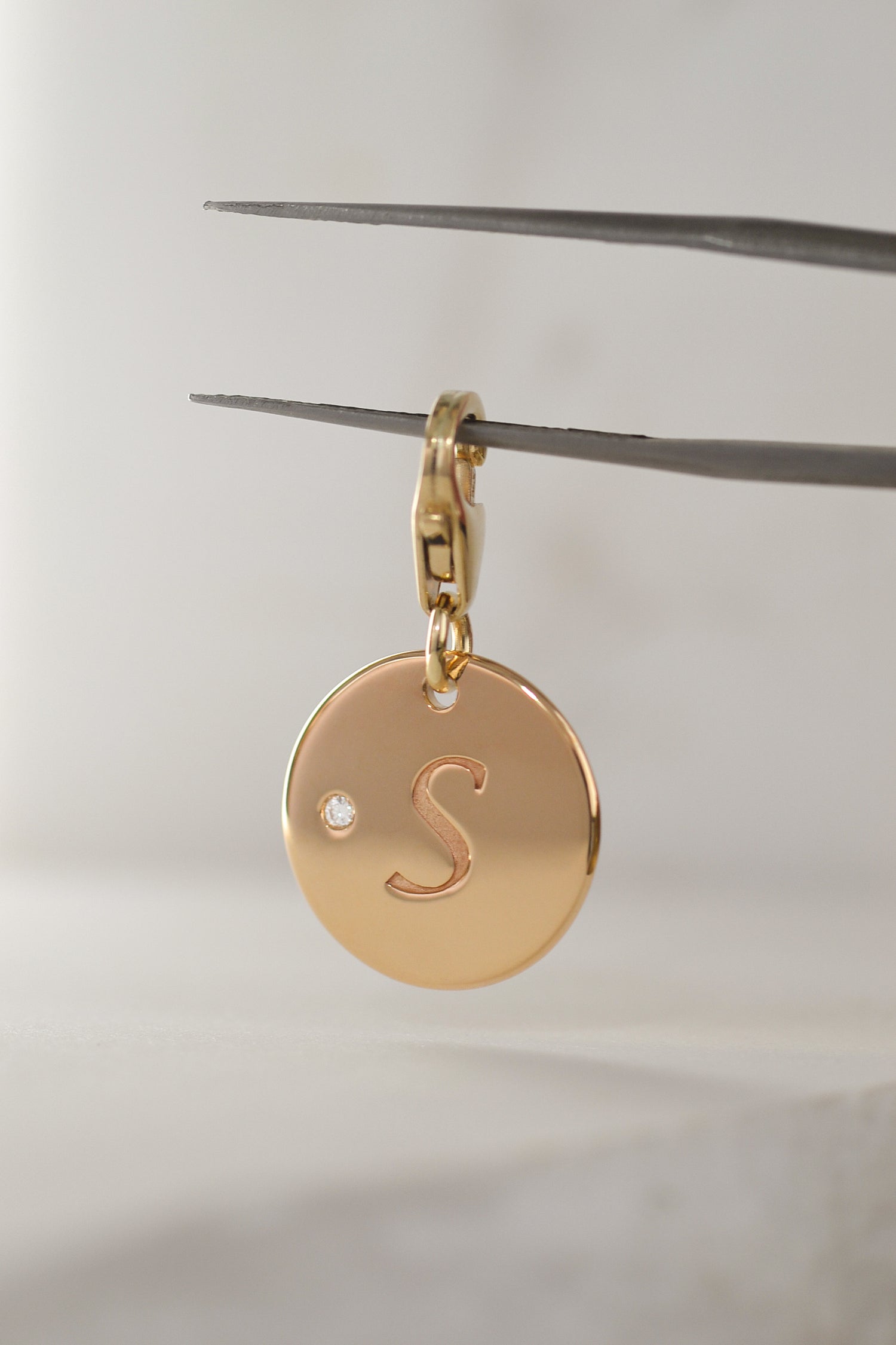Solid 9ct yellow gold pendant, with natural round brilliant cut white diamond, engraved 'S' initial. Photographed on a neutral background. SOLÈNE by PAWVÉ.